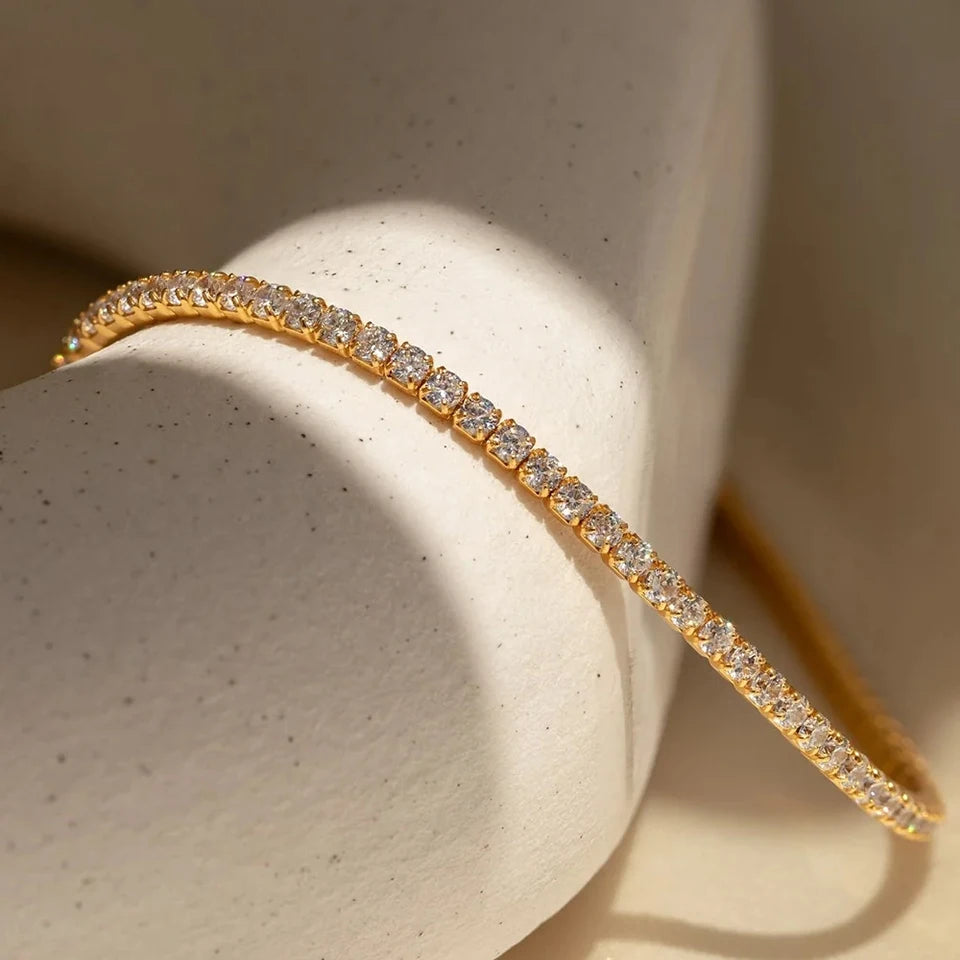 Gold bracelet with diamonds on a textured beige surface