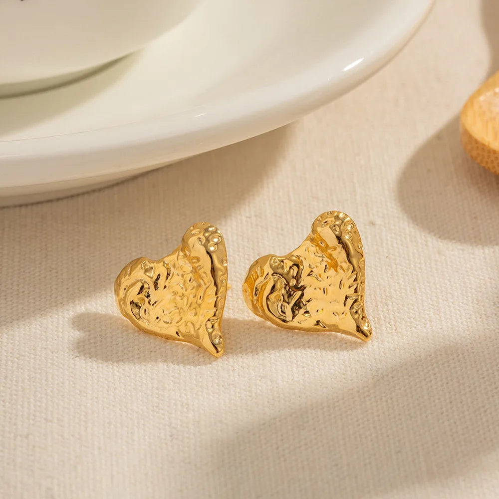 Shiny metallic love heart stud earrings with pleated 18K gold-plated stainless steel design.