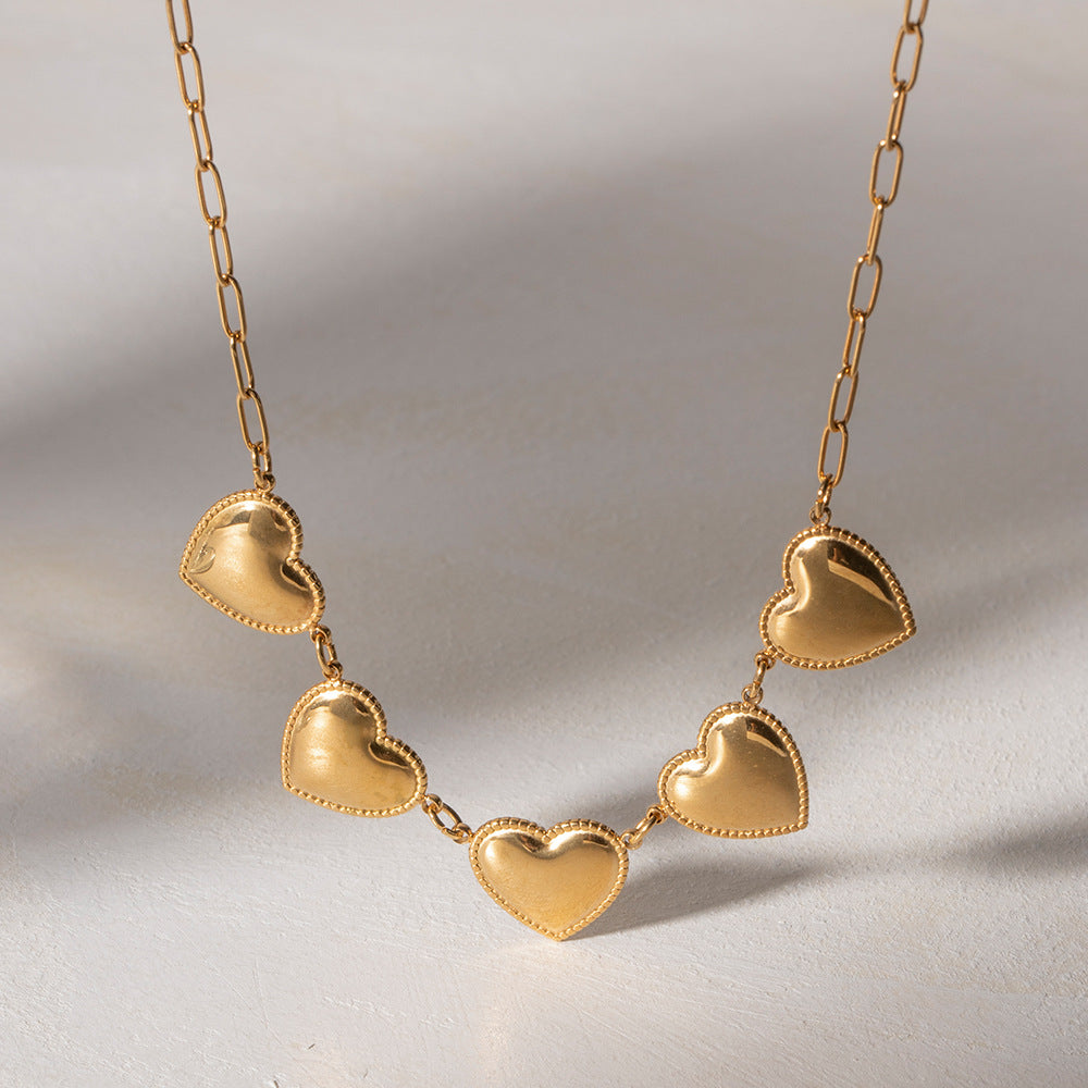 Shiny gold necklace with five heart pendants, crafted from durable stainless steel for a stylish and elegant look.