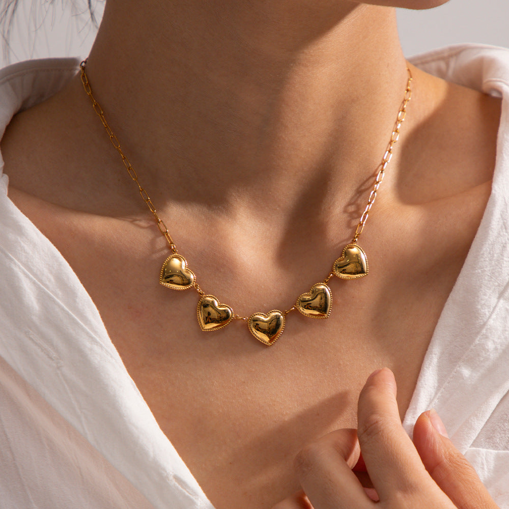 Shiny gold necklace with five heart pendants, crafted from durable stainless steel for a stylish and elegant look.