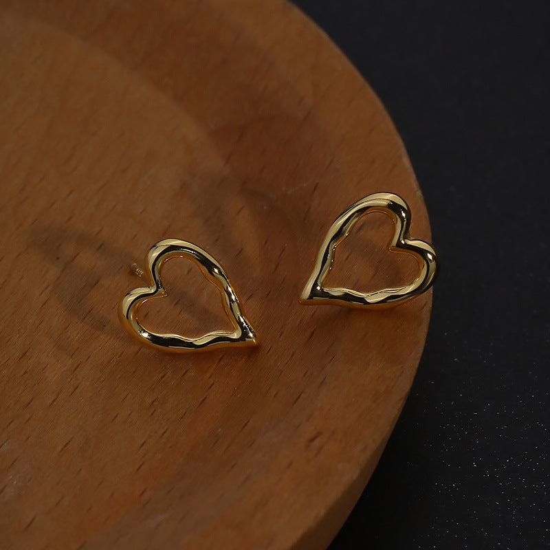 Sterling silver hollow heart ear studs, a modern and elegant accessory.