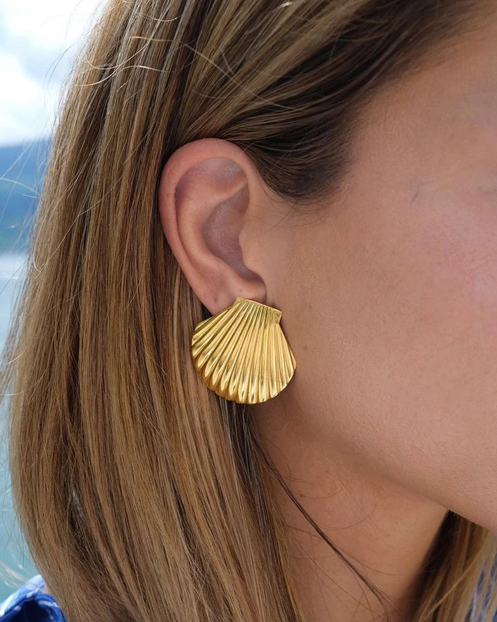 Stylish gold-plated stainless steel earrings with an intricate seashell design, offering timeless elegance and enduring quality.