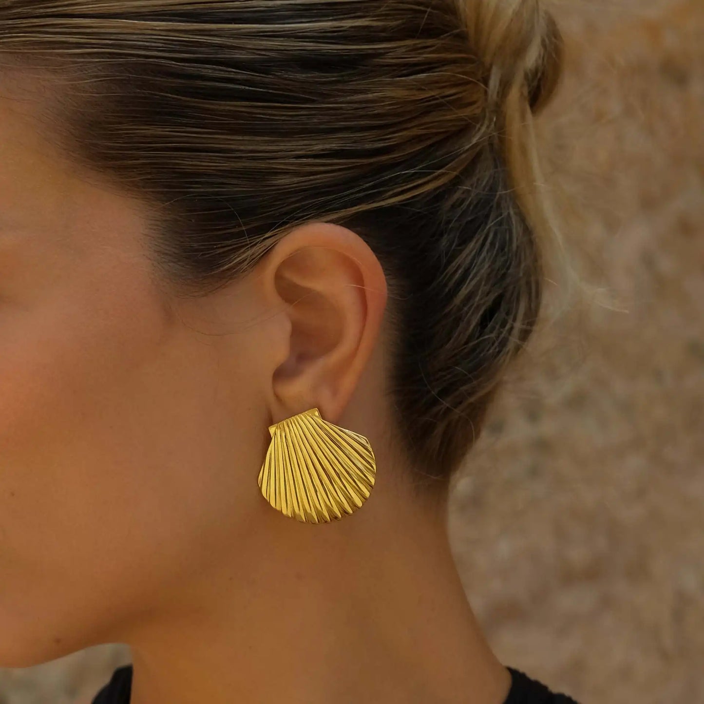 Stylish gold-plated stainless steel earrings with an intricate seashell design, offering timeless elegance and enduring quality.