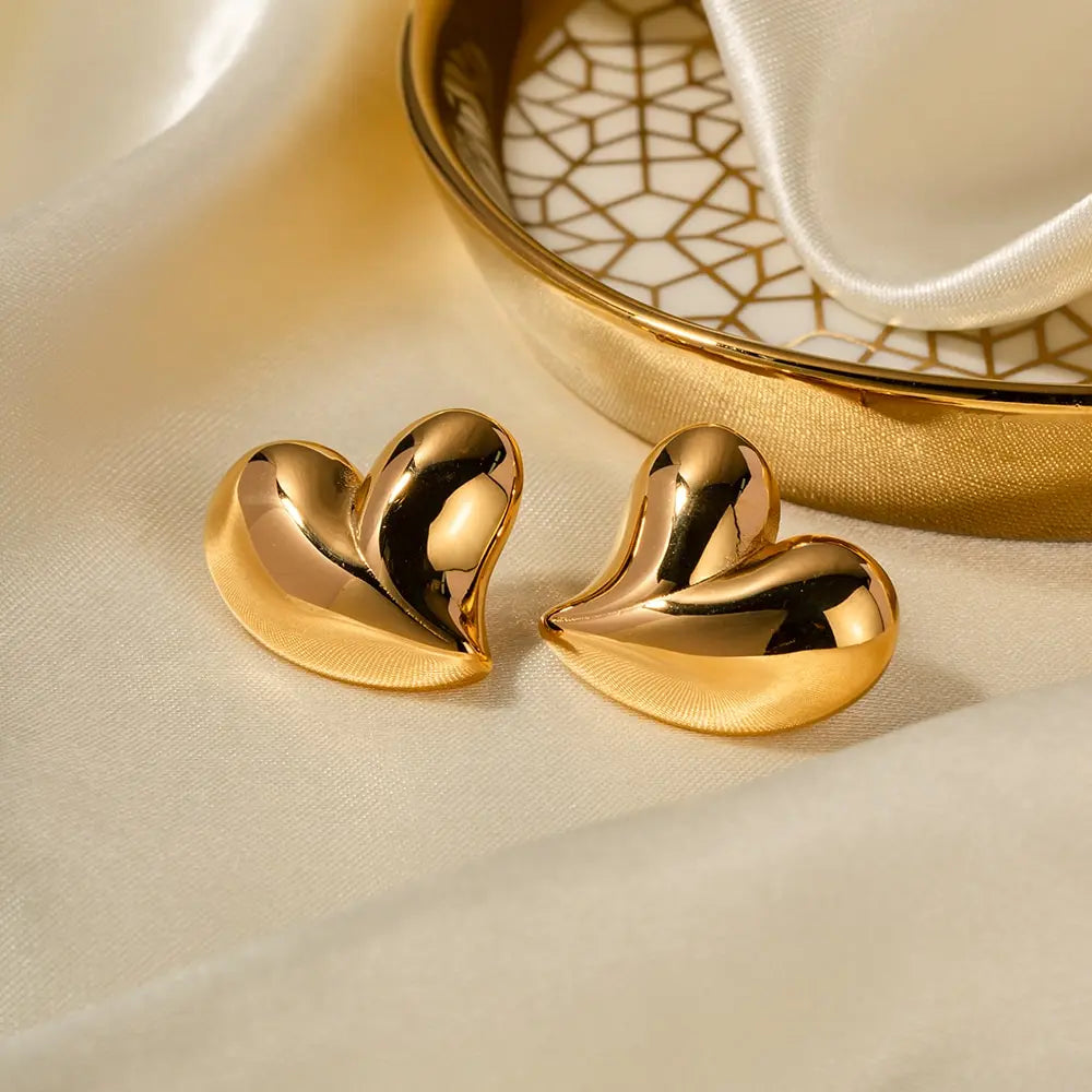 Shiny metallic love heart stud earrings with pleated 18K gold-plated stainless steel design.