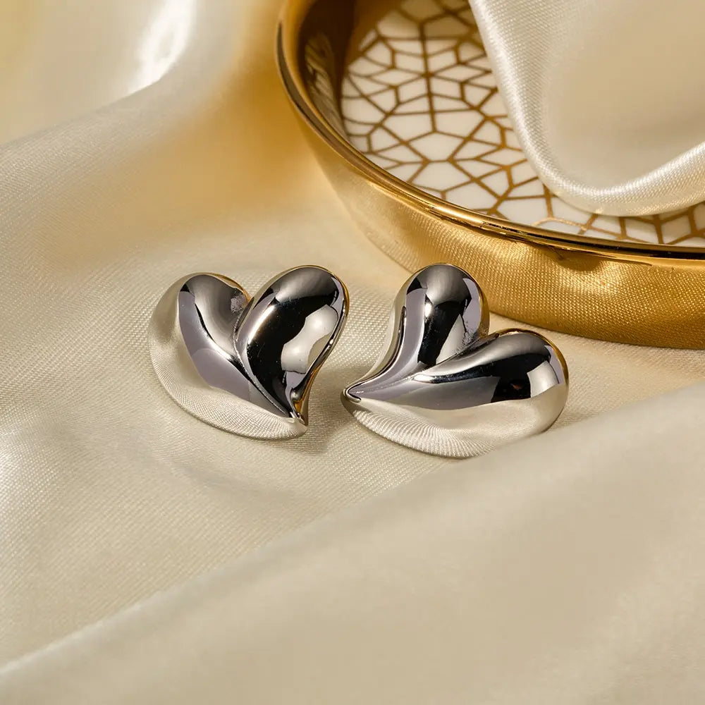 Shiny metallic love heart stud earrings with pleated 18K gold-plated stainless steel design.