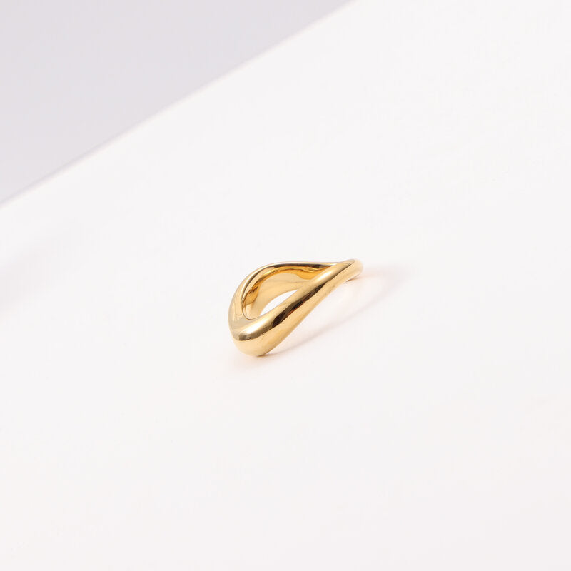 Curved gold band ring on woman's finger — PURAJOIA