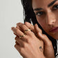 Curved gold band ring on woman's finger — PURAJOIA