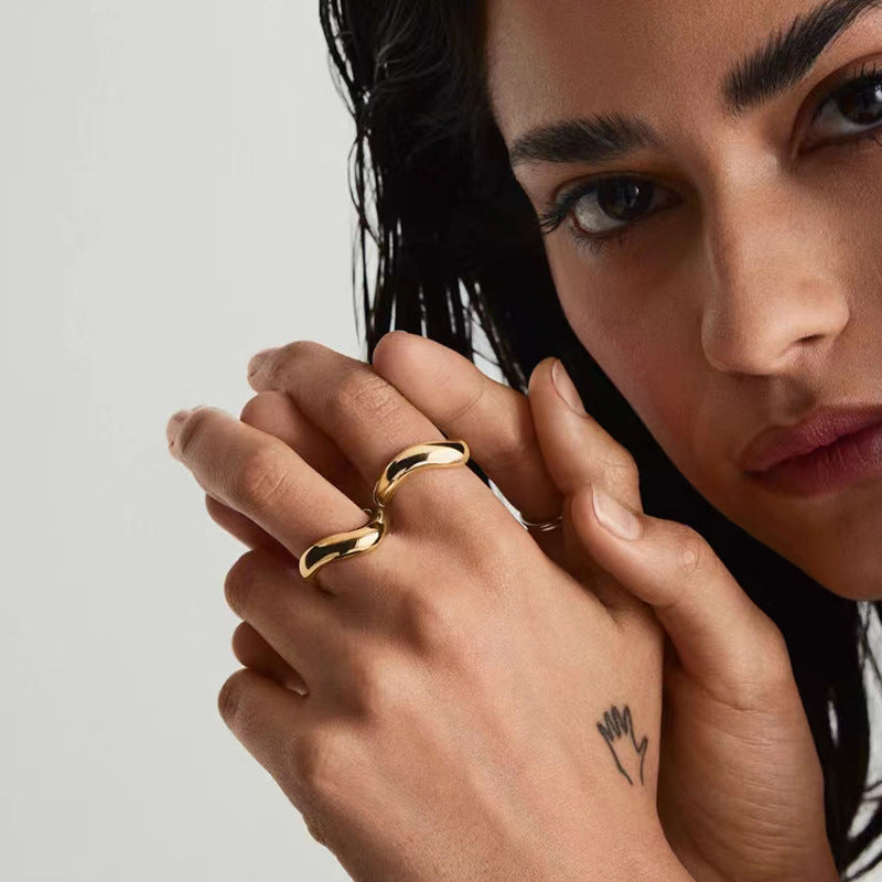 Curved gold band ring on woman's finger — PURAJOIA