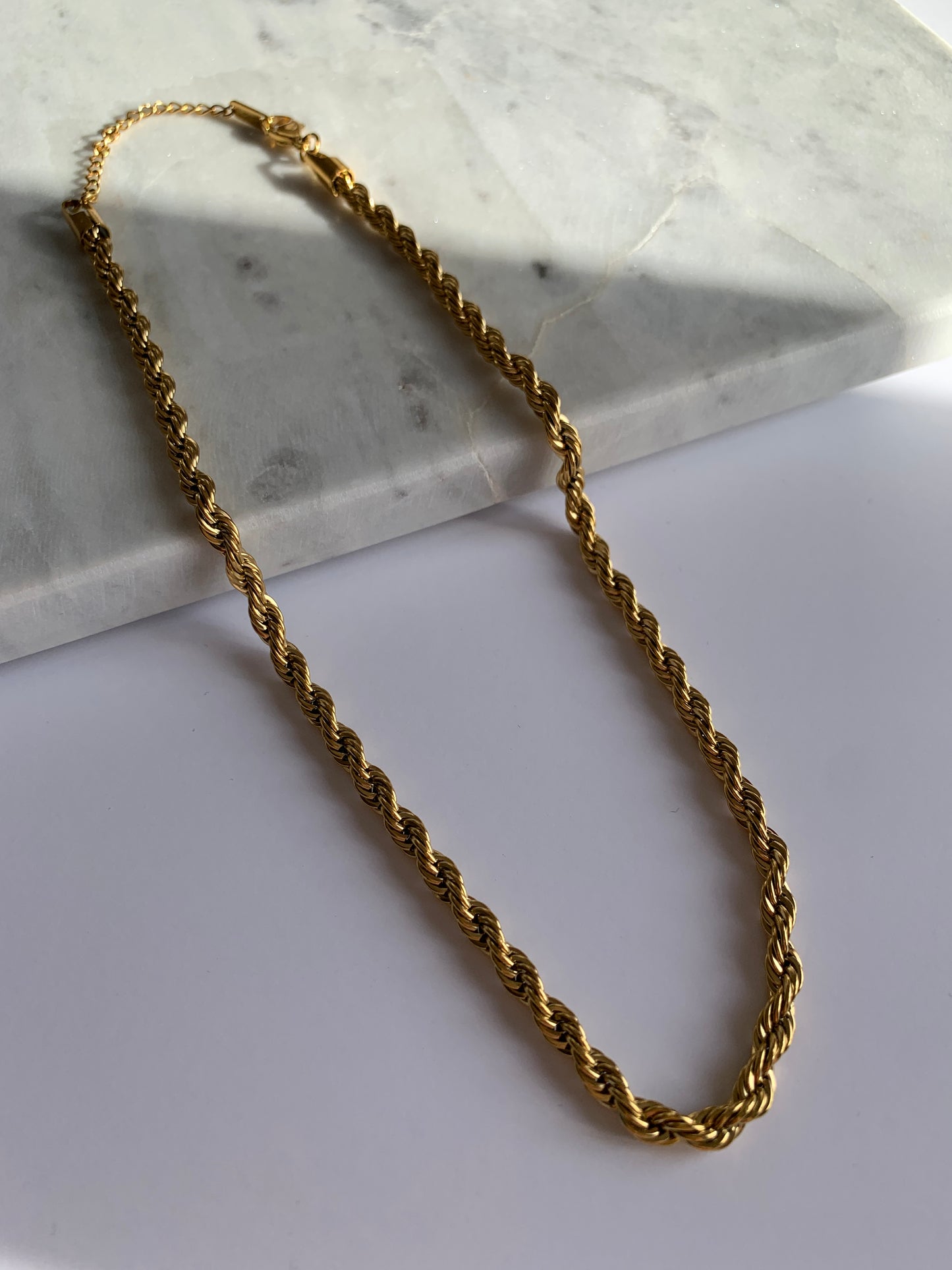 Add a unique touch to your outfit with our Twisted Chain Necklace, crafted from high-quality stainless steel and 18K gold plating for a lasting shine